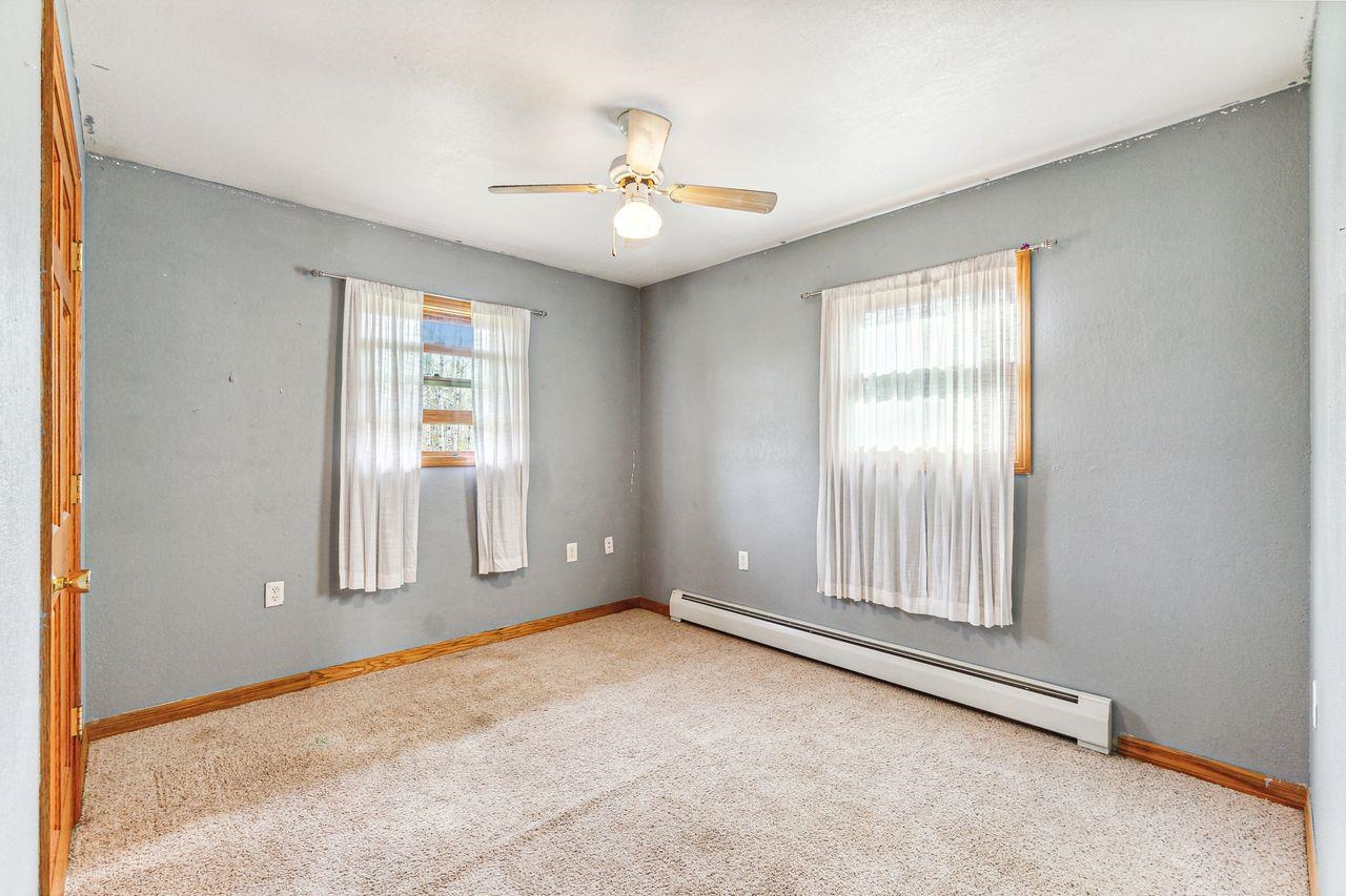 4503 Snooky Road South Range, WI 54874 - Photo 10 of 21 Empty room with a baseboard heating unit, light carpet, and plenty of natural light