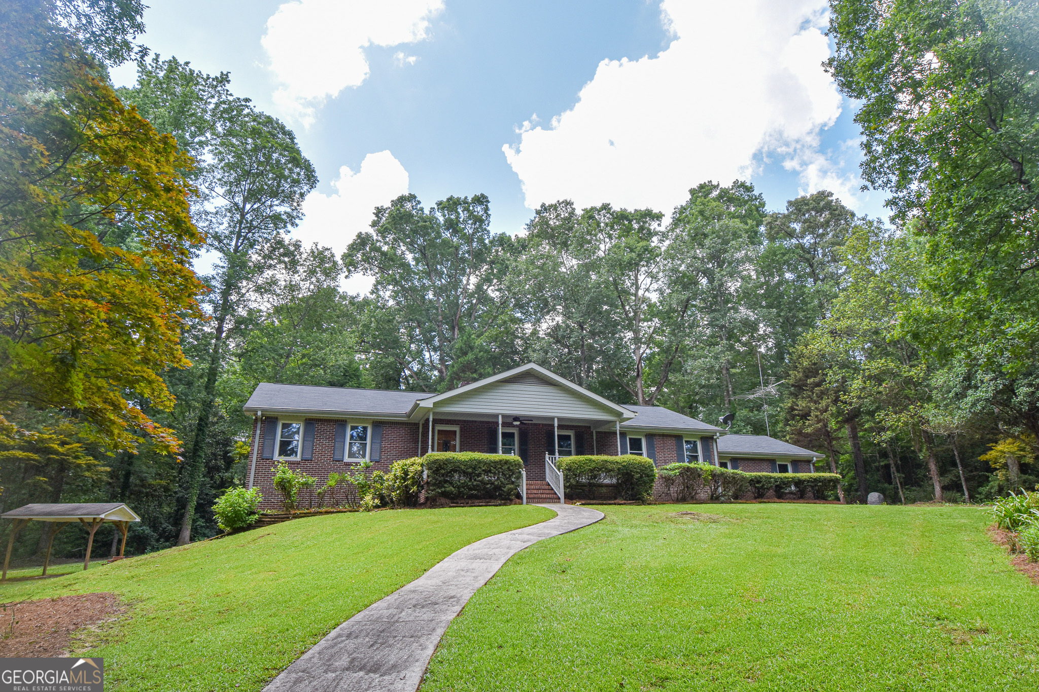 a front view of a house with yard and green space