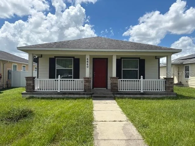 a view of a house with a yard and large trees