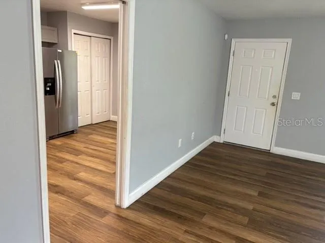 a view of a hallway with wooden floor and closet