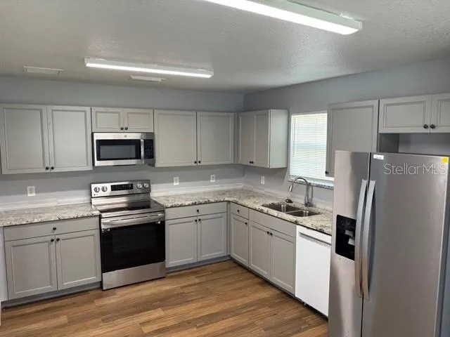 a kitchen with stainless steel appliances granite countertop a refrigerator stove a sink and microwave