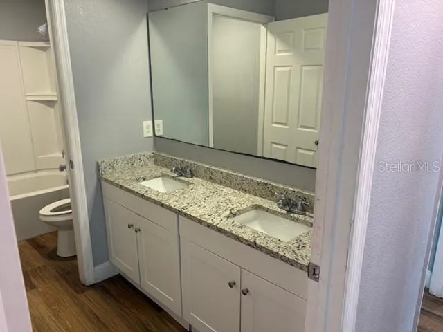 a bathroom with a granite countertop sink and a mirror