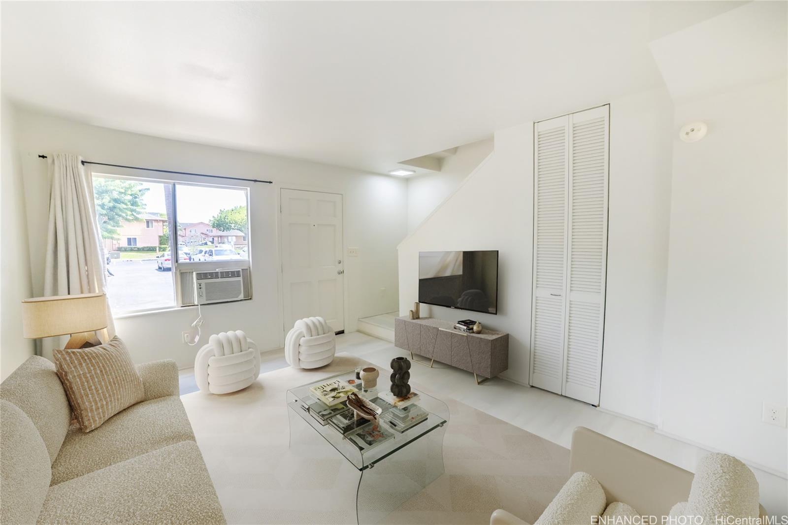 91-1147 Kamaaha Loop, Unit 6F Kapolei, HI 96707 - Photo 3 of 25 a living room with furniture a flat screen tv and a window