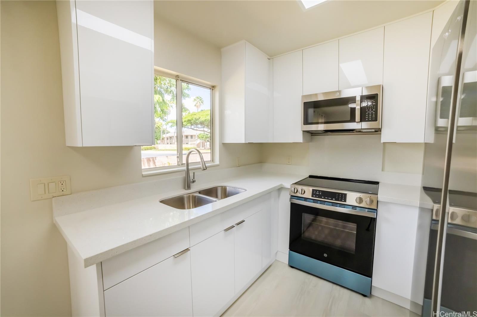 91-1147 Kamaaha Loop, Unit 6F Kapolei, HI 96707 - Photo 9 of 25 a kitchen with stainless steel appliances a stove microwave and sink