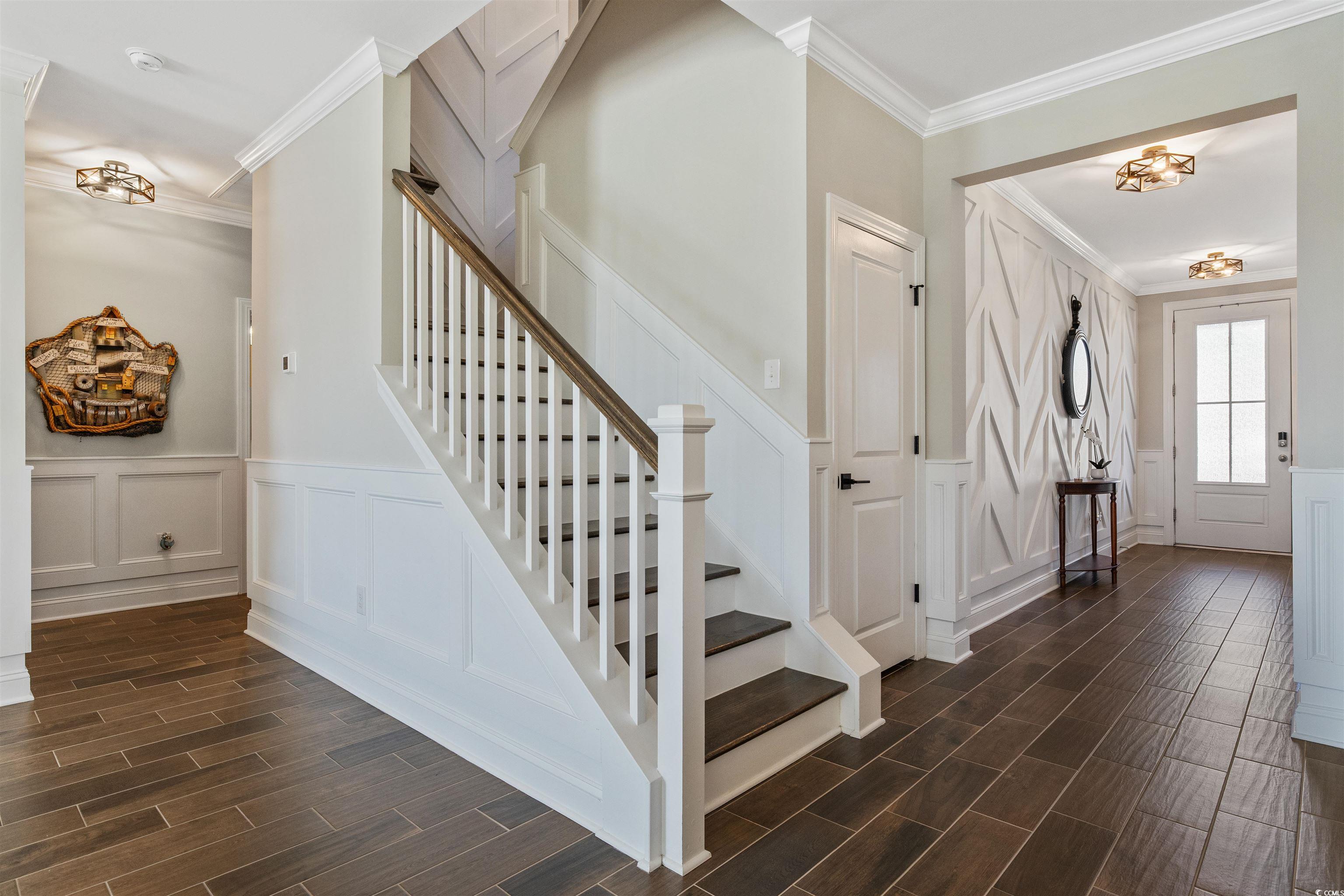 5286 Stockyard Loop Myrtle Beach, SC 29588 - Photo 13 of 40 Stairway with ornamental molding, wood tiled floors, a decorative wall, and wainscoting