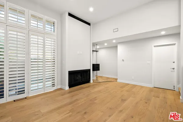 a view of an empty room with a fireplace and a window