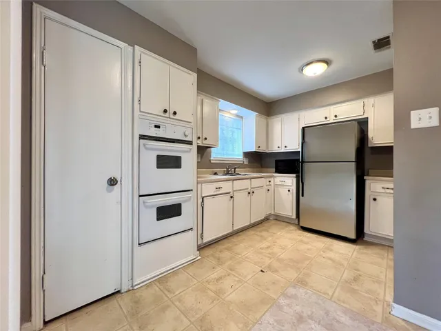 a kitchen with stainless steel appliances a refrigerator sink and microwave