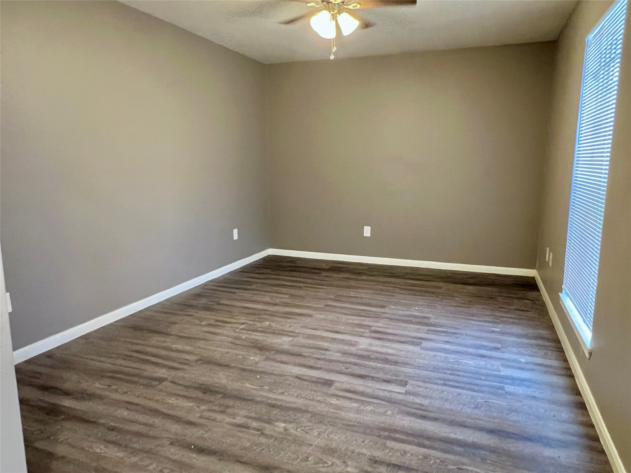12819 Claygate Drive Houston, TX 77047 - Photo 3 of 12 a view of an empty room with wooden floor and a window