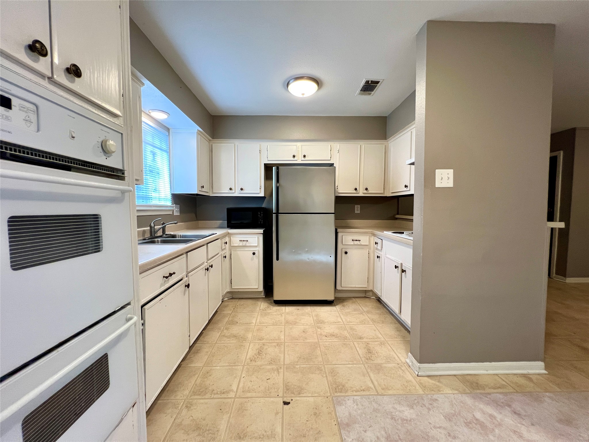 12819 Claygate Drive Houston, TX 77047 - Photo 5 of 12 a kitchen with granite countertop a refrigerator sink stove and cabinets