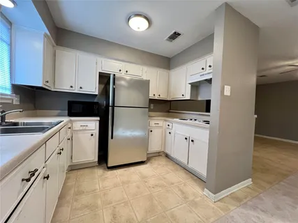 a kitchen with white cabinets and white appliances