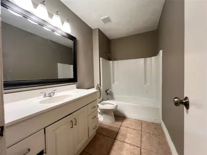 a bathroom with a double vanity sink toilet mirror and bathtub