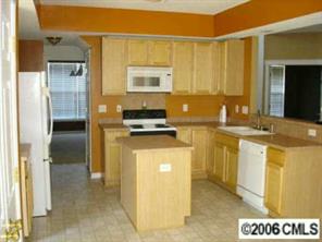 5603 Falls Ridge Lane Charlotte, NC 28269 - Photo 3 of 5 a kitchen with stainless steel appliances granite countertop a refrigerator a stove and a sink with wooden floor