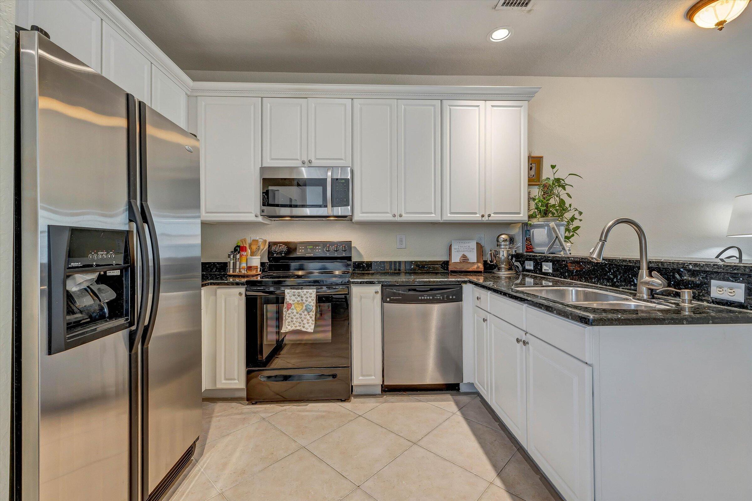 115 Pond Apple Lane, Unit 105 Jupiter, FL 33458 - Photo 11 of 38 a kitchen with a sink appliances and cabinets