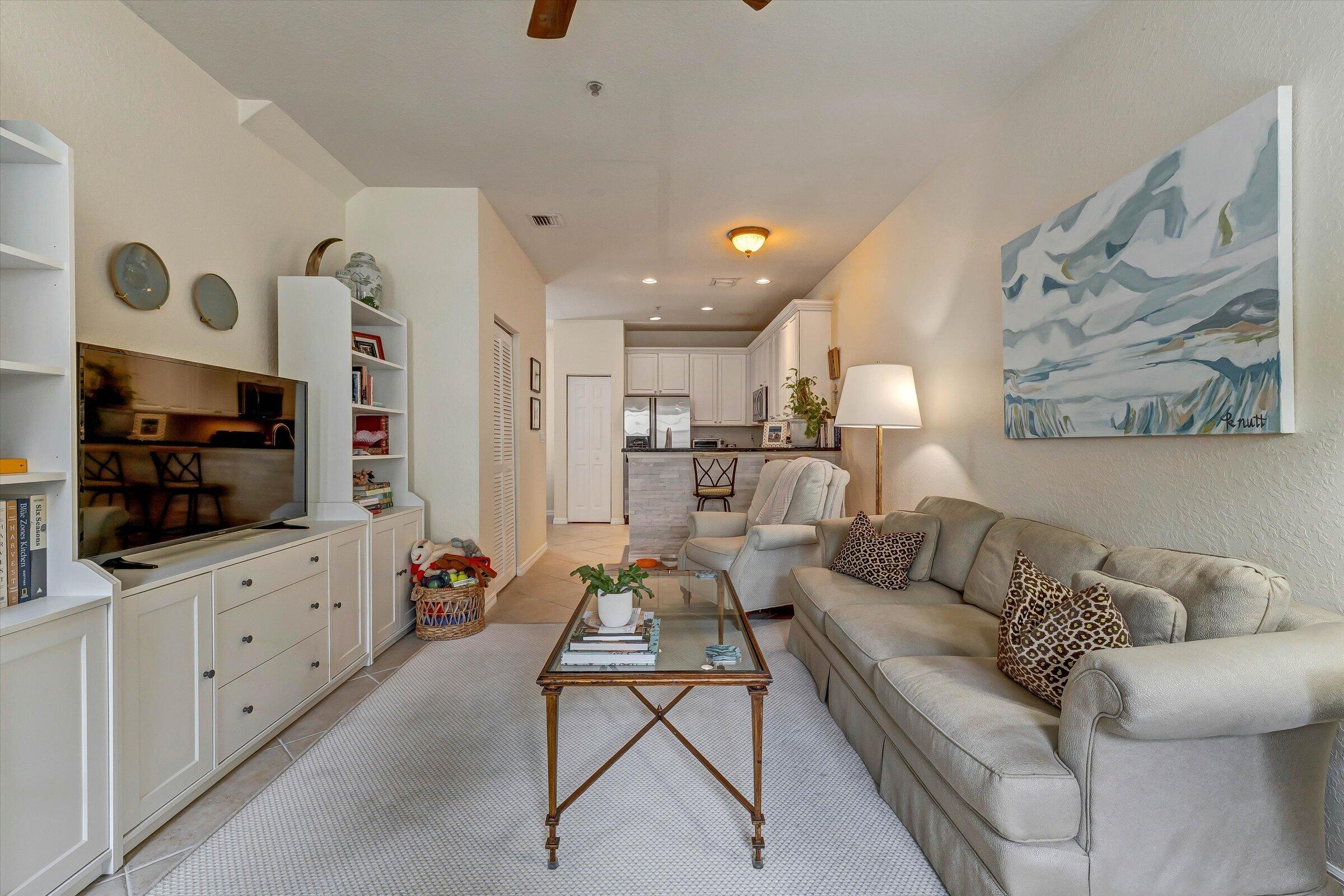 115 Pond Apple Lane, Unit 105 Jupiter, FL 33458 - Photo 15 of 38 a living room with furniture and a flat screen tv