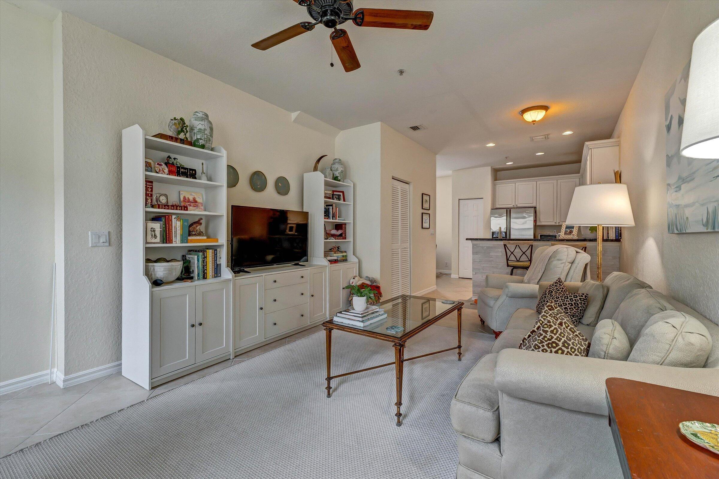 115 Pond Apple Lane, Unit 105 Jupiter, FL 33458 - Photo 18 of 38 a living room with furniture and a flat screen tv
