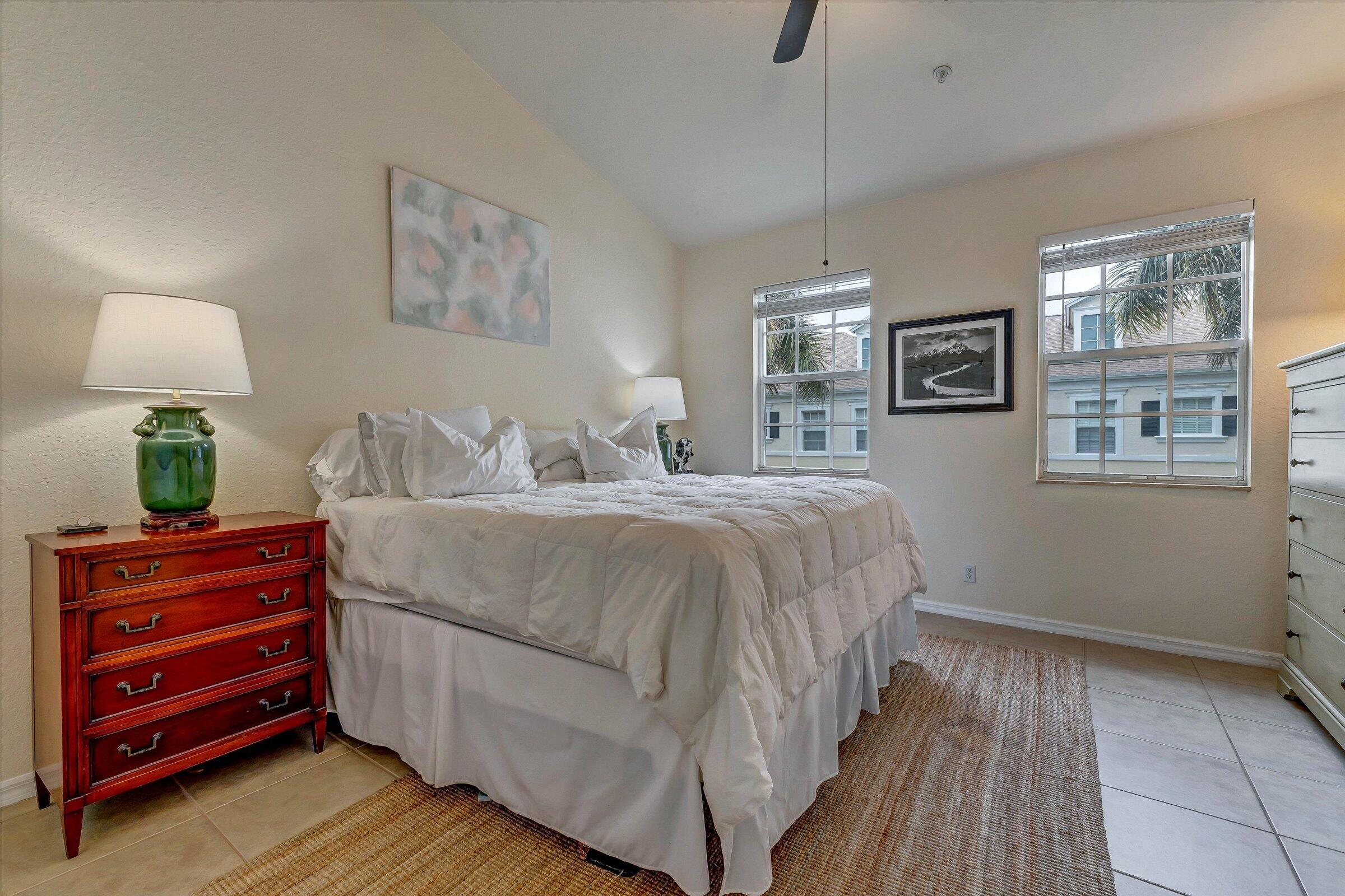 115 Pond Apple Lane, Unit 105 Jupiter, FL 33458 - Photo 21 of 38 a bedroom with a bed and a lamp on dresser