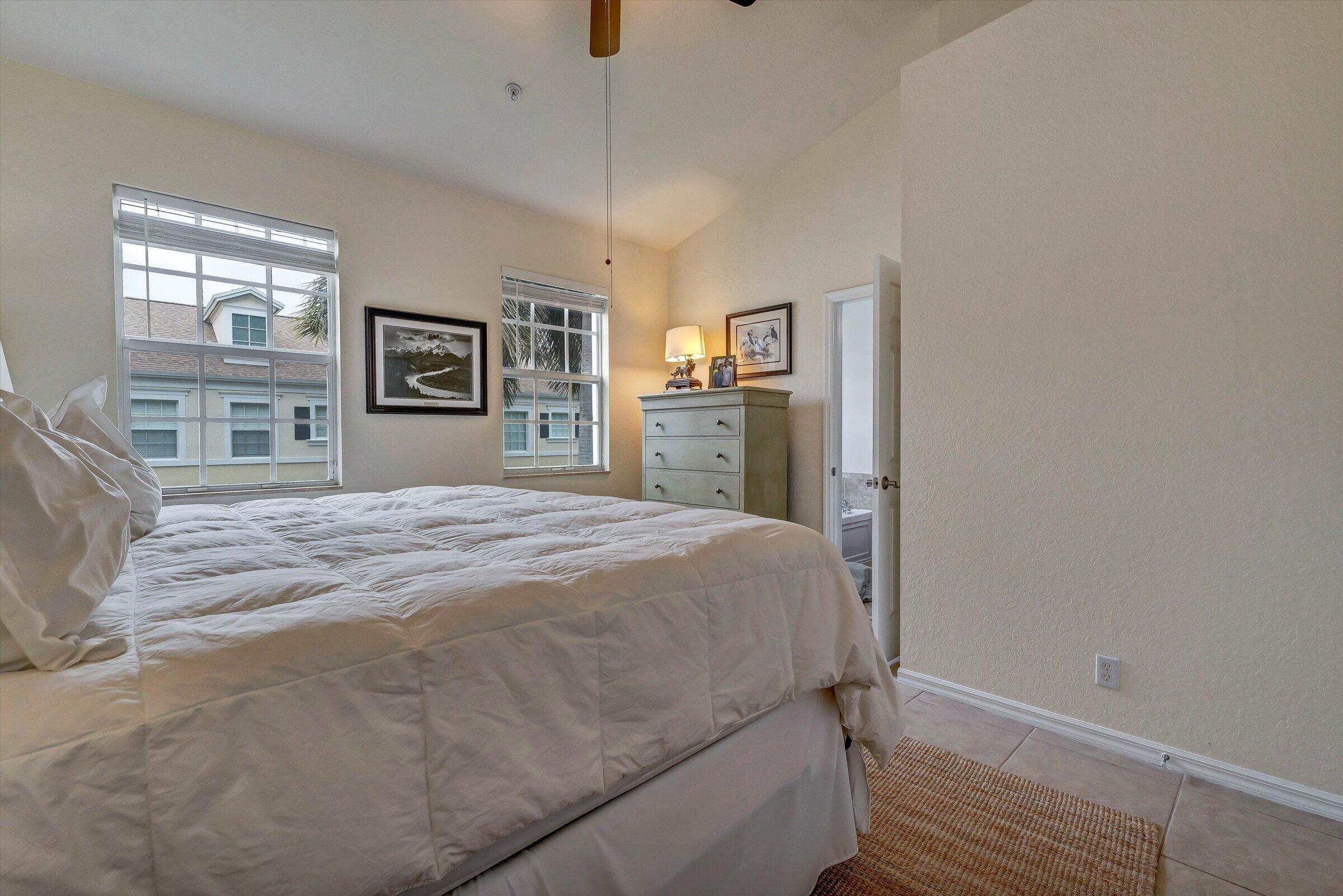 115 Pond Apple Lane, Unit 105 Jupiter, FL 33458 - Photo 22 of 38 a bedroom with a large bed and a window