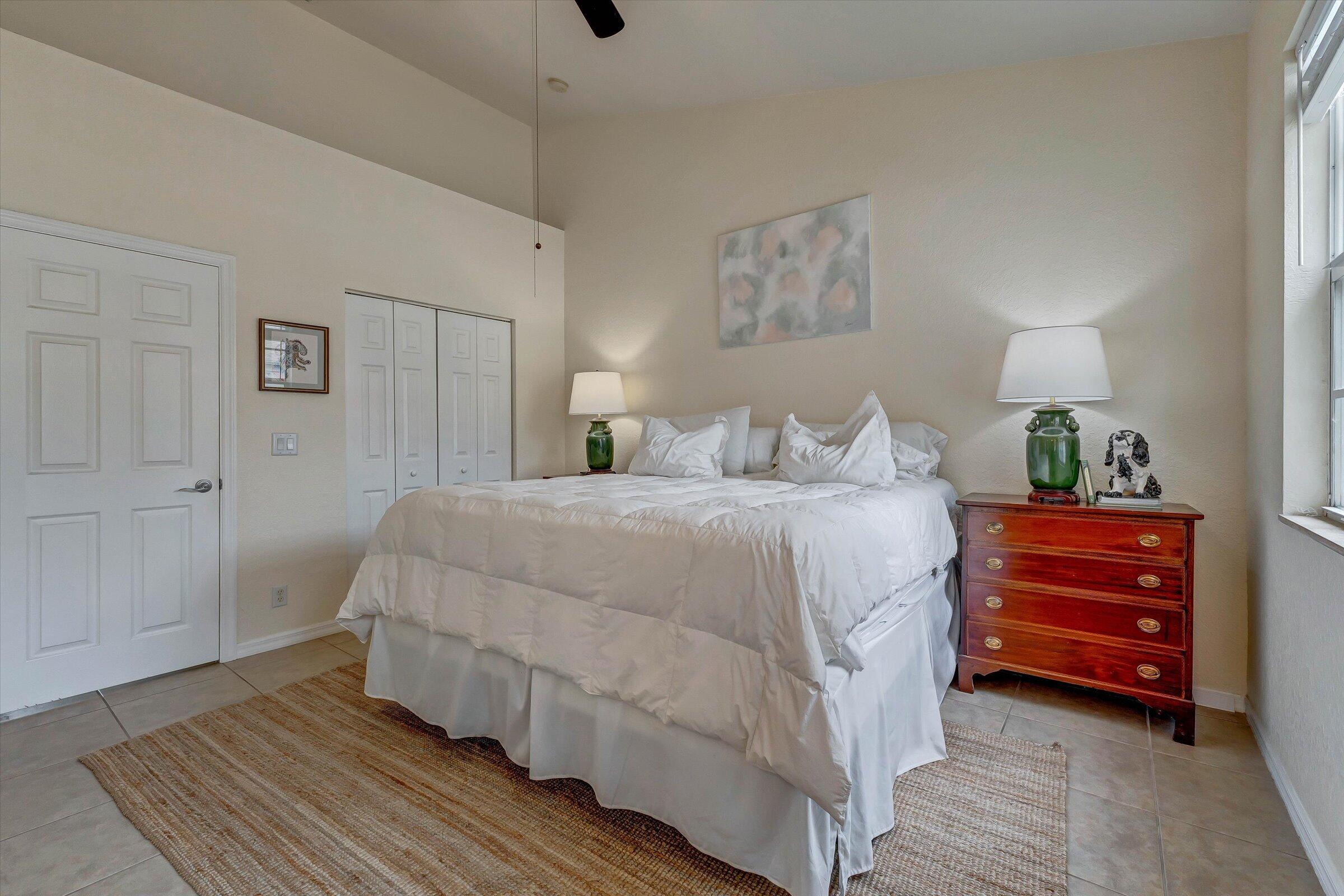 115 Pond Apple Lane, Unit 105 Jupiter, FL 33458 - Photo 23 of 38 a bed room with a bed and a lamp