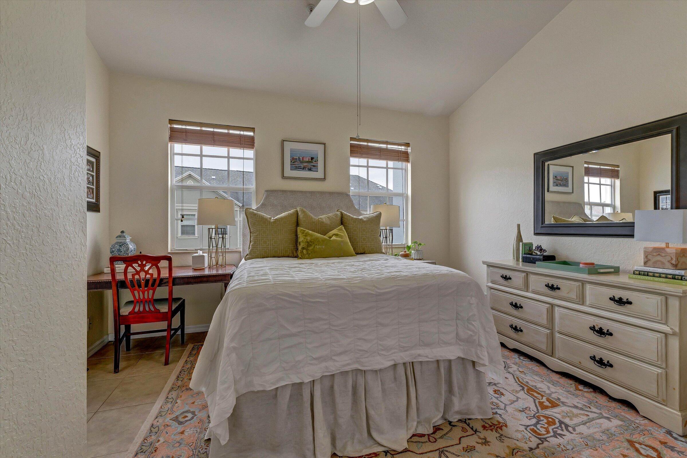 115 Pond Apple Lane, Unit 105 Jupiter, FL 33458 - Photo 24 of 38 a bedroom with a bed and a dresser in it