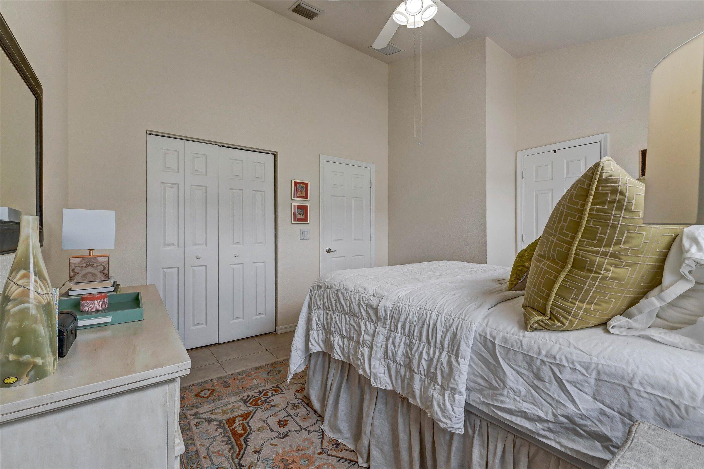 115 Pond Apple Lane, Unit 105 Jupiter, FL 33458 - Photo 25 of 38 a bedroom with a bed and a flat screen tv