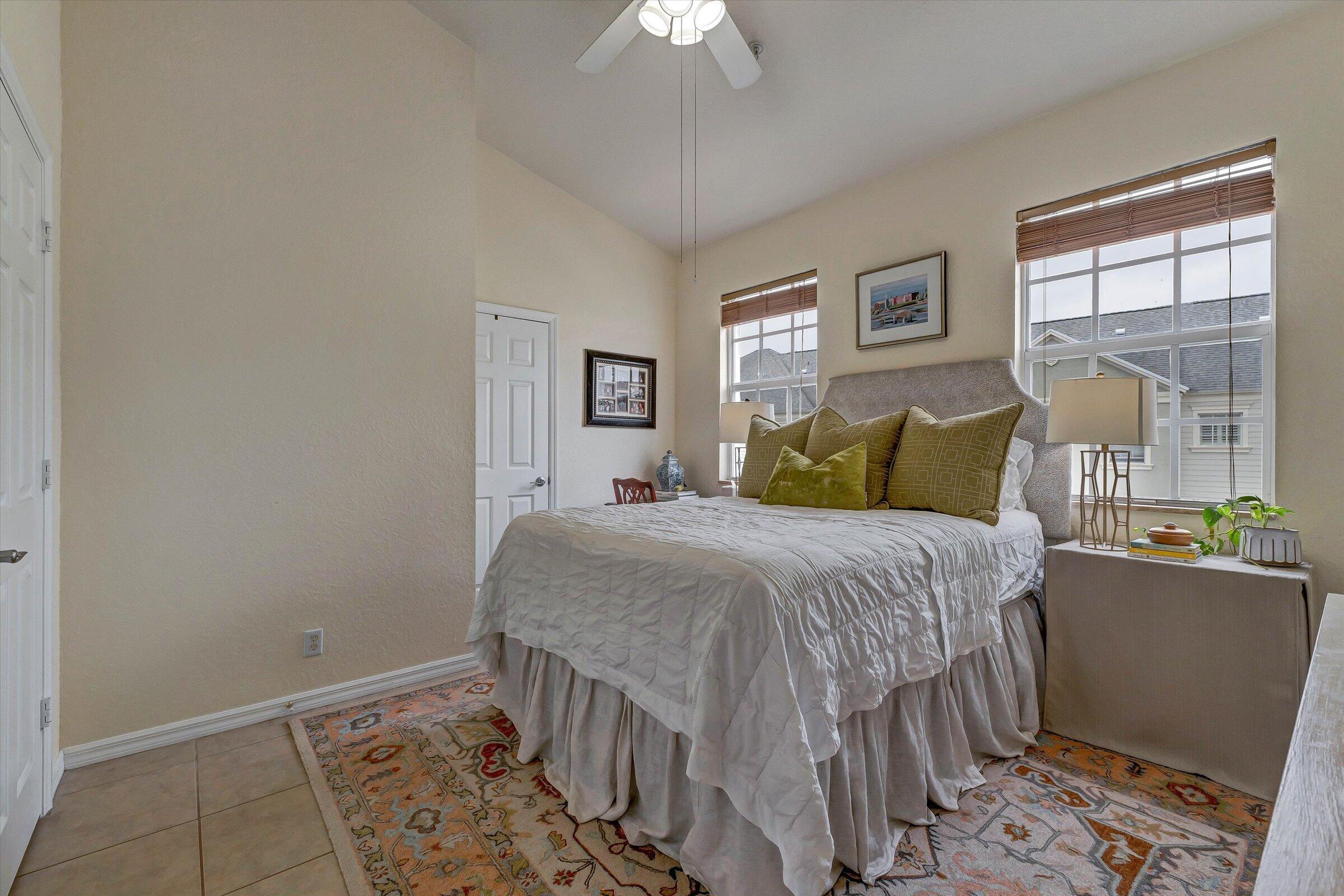 115 Pond Apple Lane, Unit 105 Jupiter, FL 33458 - Photo 26 of 38 a bedroom with a bed and a chandelier