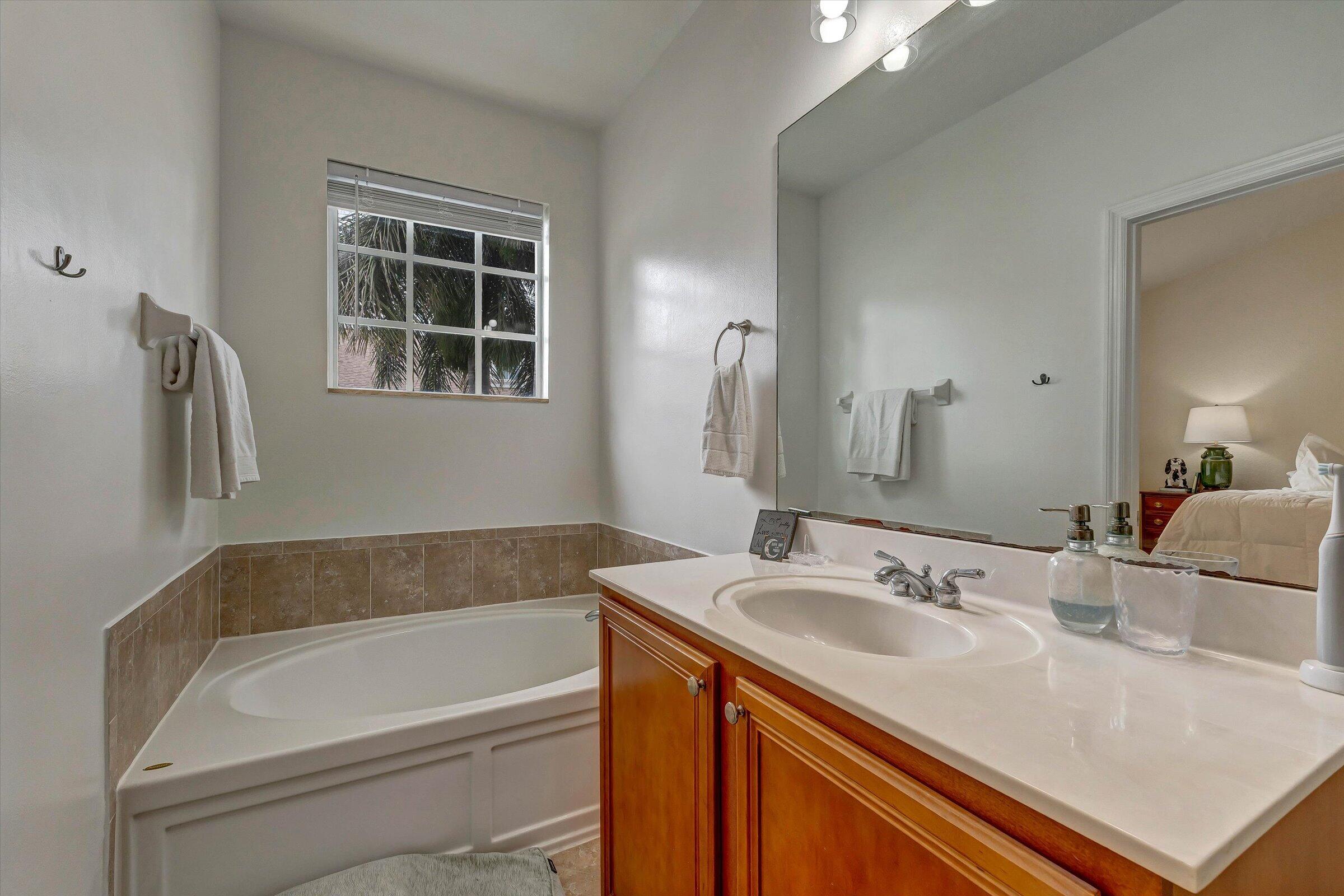 115 Pond Apple Lane, Unit 105 Jupiter, FL 33458 - Photo 34 of 38 a bathroom with a sink and a bathtub
