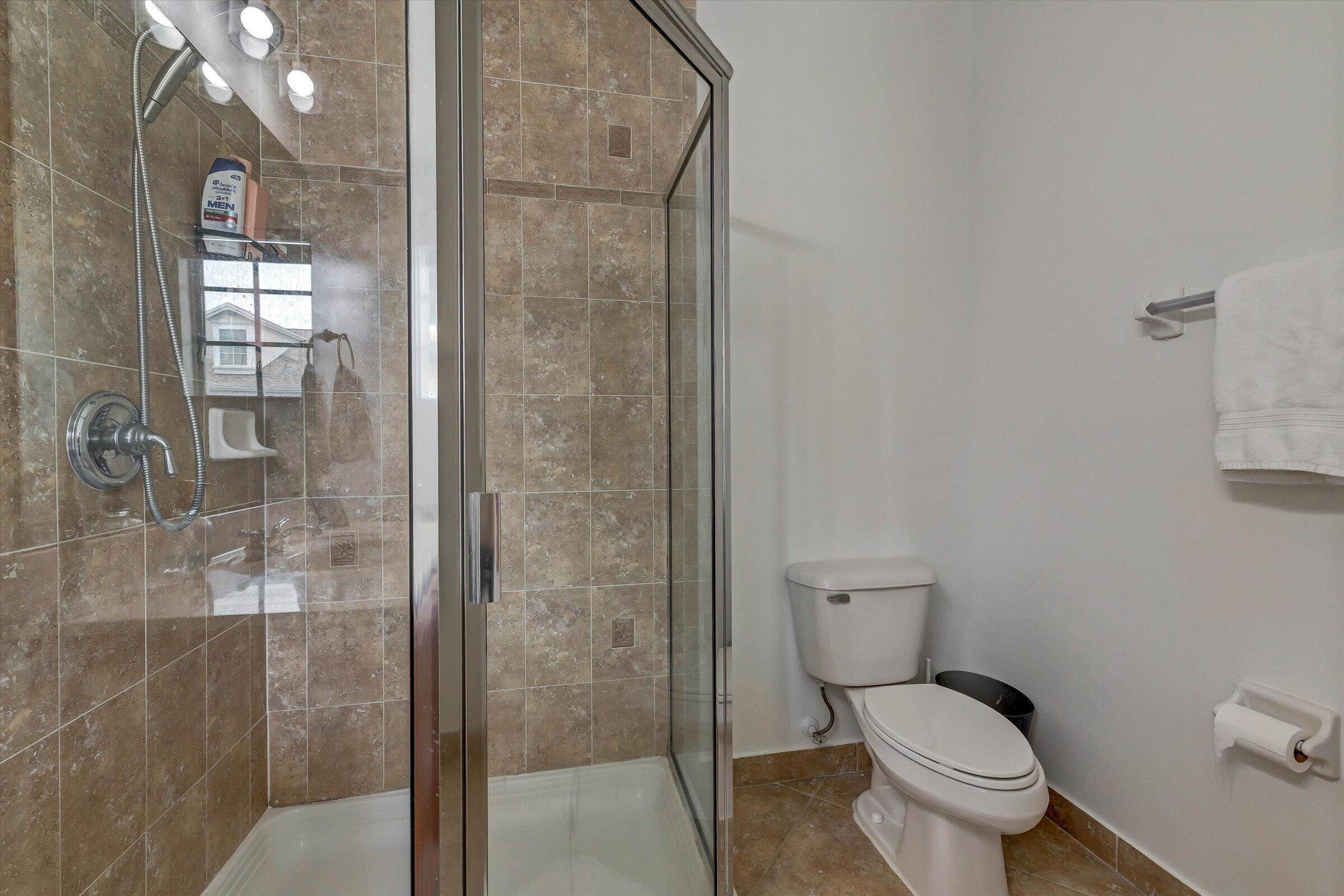 115 Pond Apple Lane, Unit 105 Jupiter, FL 33458 - Photo 37 of 38 a bathroom with a toilet and a shower