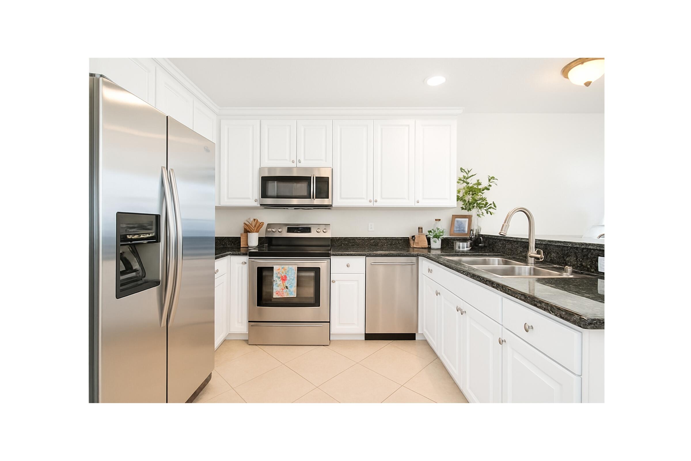 115 Pond Apple Lane, Unit 105 Jupiter, FL 33458 - Photo 9 of 38 a kitchen with a sink stainless steel appliances and white cabinets