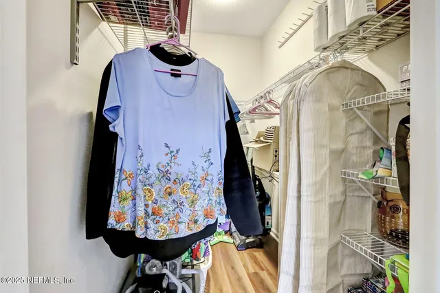 a view of walk in closet with clothes