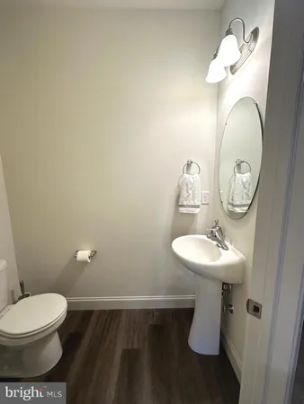 a bathroom with a toilet a sink and mirror