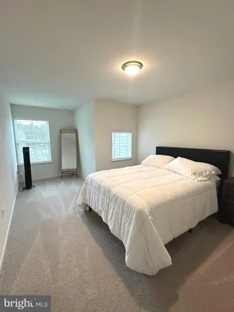 a spacious bedroom with a bed and a mirror