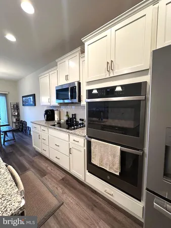 a kitchen with stainless steel appliances a stove microwave and sink