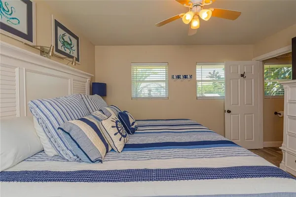 a view of a bedroom with wooden floor and windows