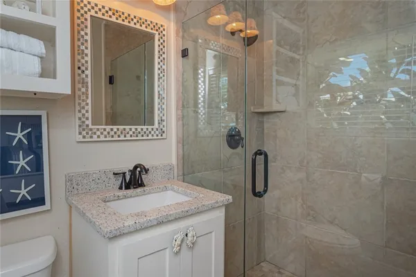 a bathroom with a granite countertop sink a toilet and shower
