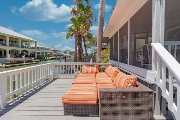 a view of a house with a wooden deck and a yard