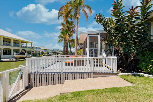 a view of a patio with table and chairs potted plants with wooden floor and fence