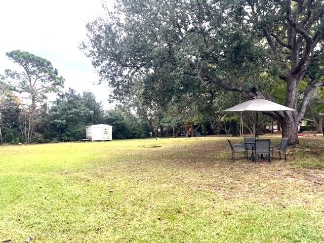 1860 Eagle Lane Navarre, FL 32566 - Photo 28 of 34 a swimming pool with outdoor seating yard and trees