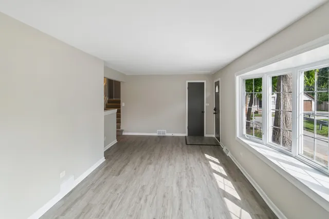 wooden floor in an empty room with a window
