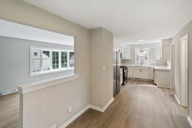 a view of a kitchen with wooden floor and electronic appliances