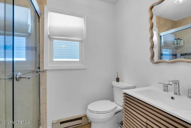 a bathroom with a sink a toilet and a mirror