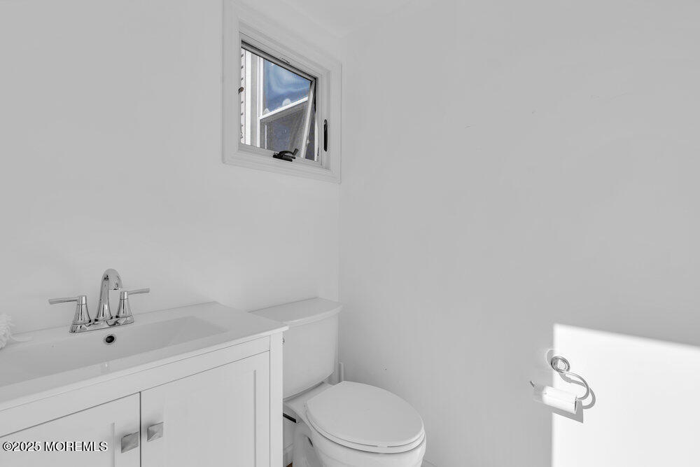 234 3rd Avenue Manasquan, NJ 08736 - Photo 21 of 25 a bathroom with a toilet sink and mirror