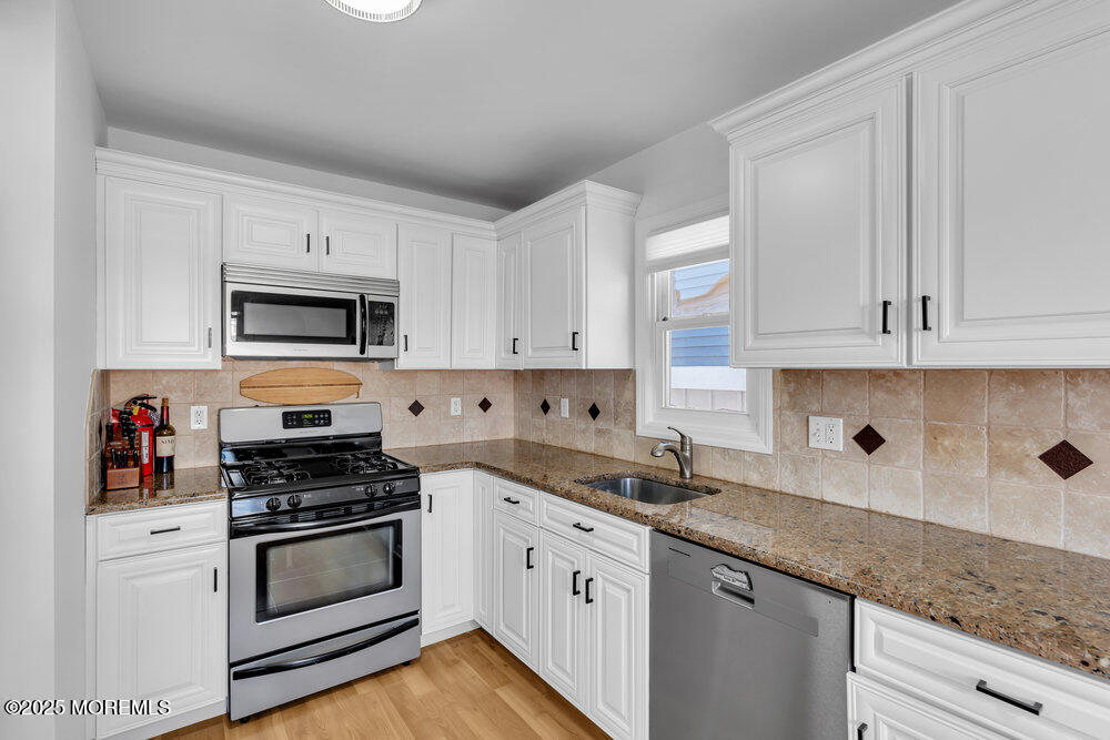 234 3rd Avenue Manasquan, NJ 08736 - Photo 10 of 25 a kitchen with granite countertop white cabinets and stainless steel appliances