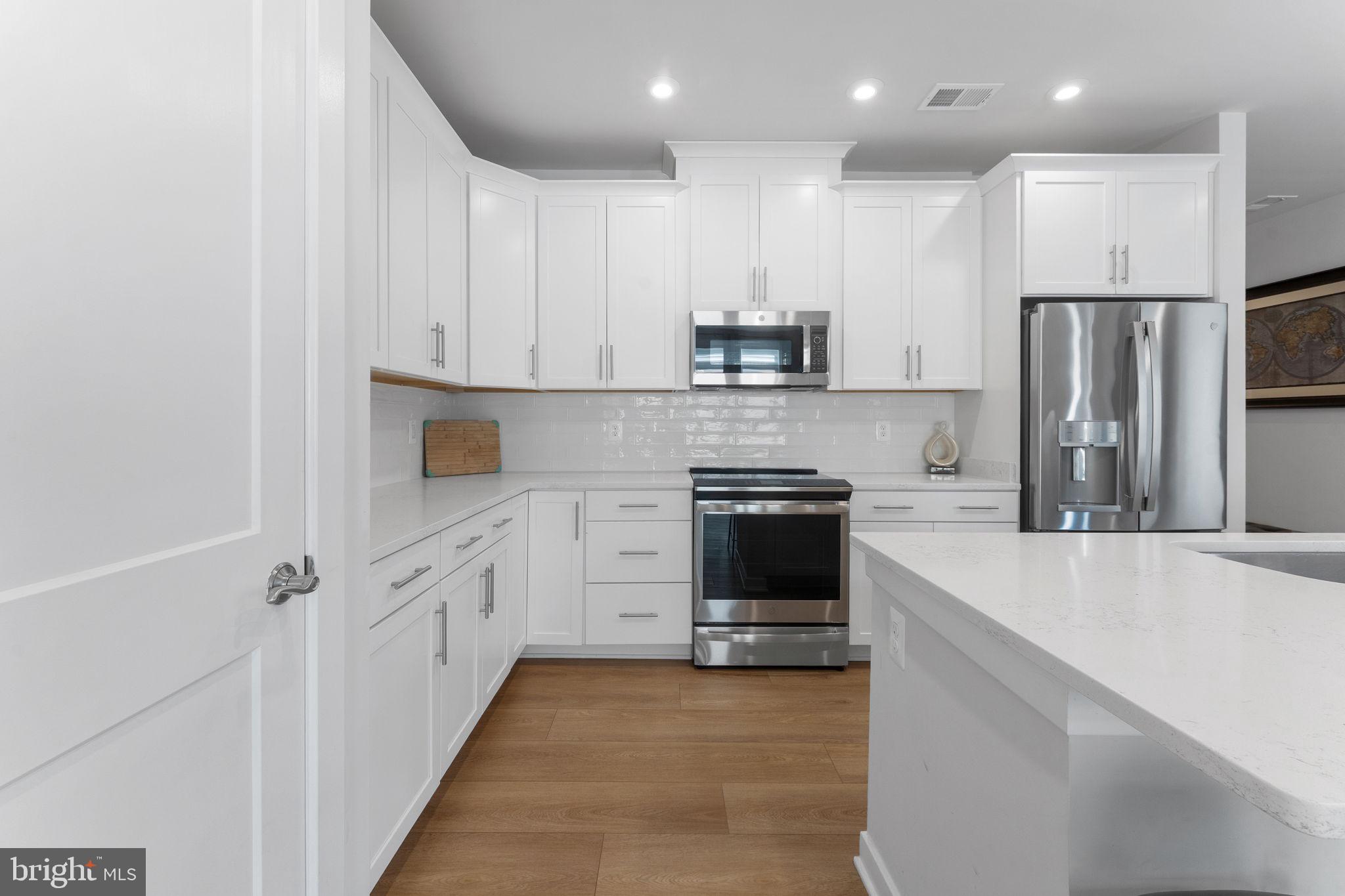 1669 Bandit Loop, Unit 101A Reston, VA 20190 - Photo 12 of 35 a kitchen with stainless steel appliances a refrigerator sink and white cabinets