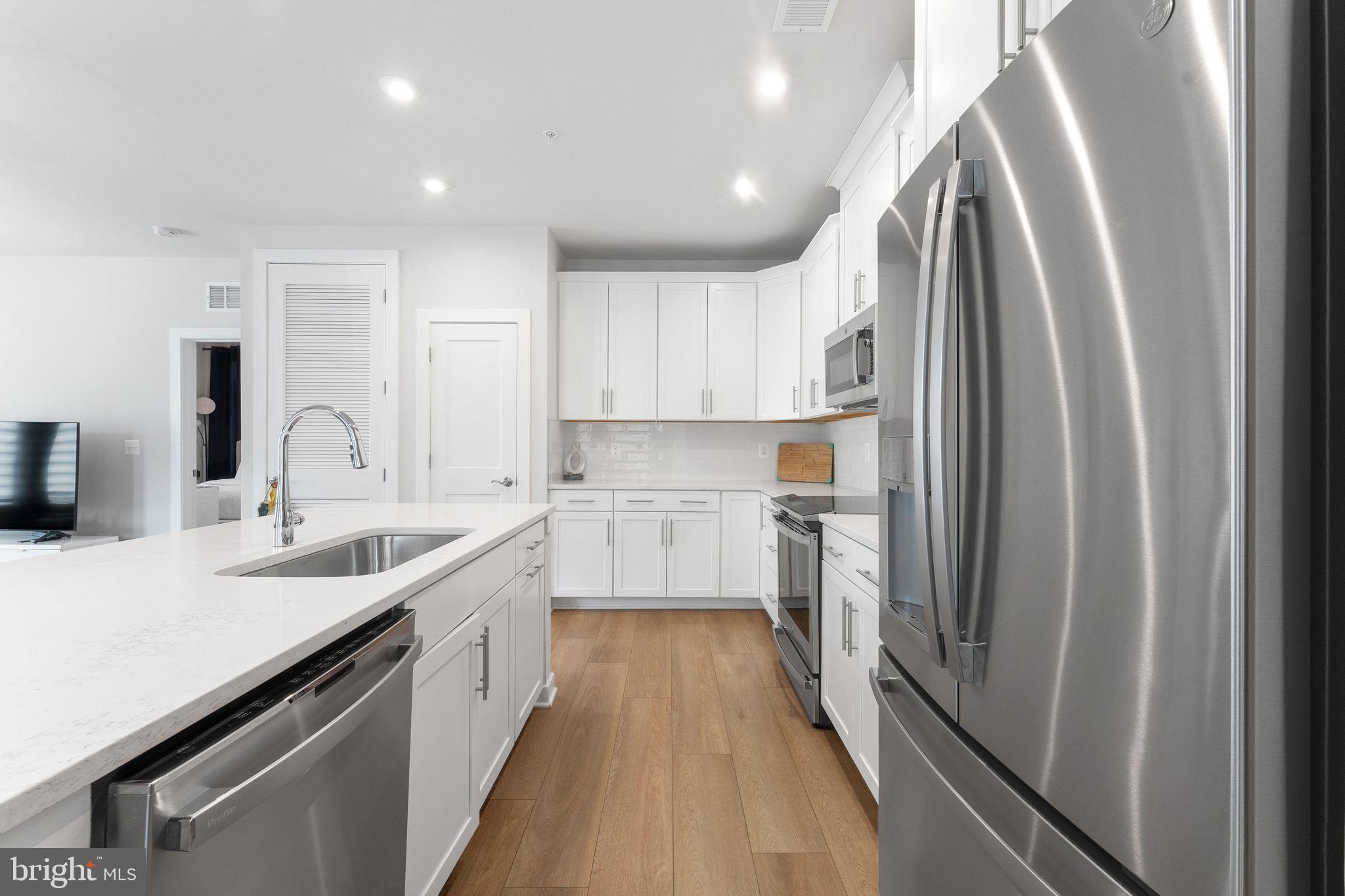 1669 Bandit Loop, Unit 101A Reston, VA 20190 - Photo 13 of 35 a kitchen with white cabinets and stainless steel appliances
