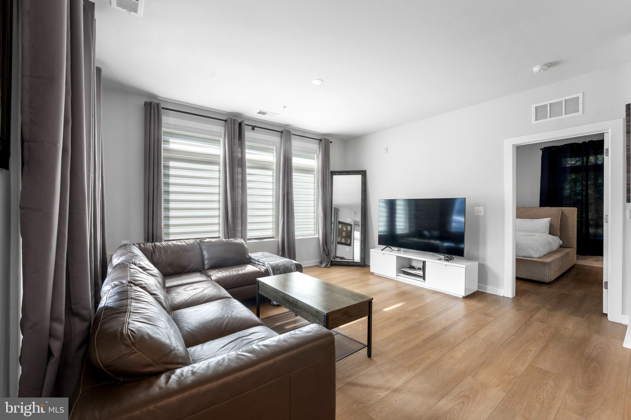 1669 Bandit Loop, Unit 101A Reston, VA 20190 - Photo 15 of 35 a living room with furniture and a flat screen tv