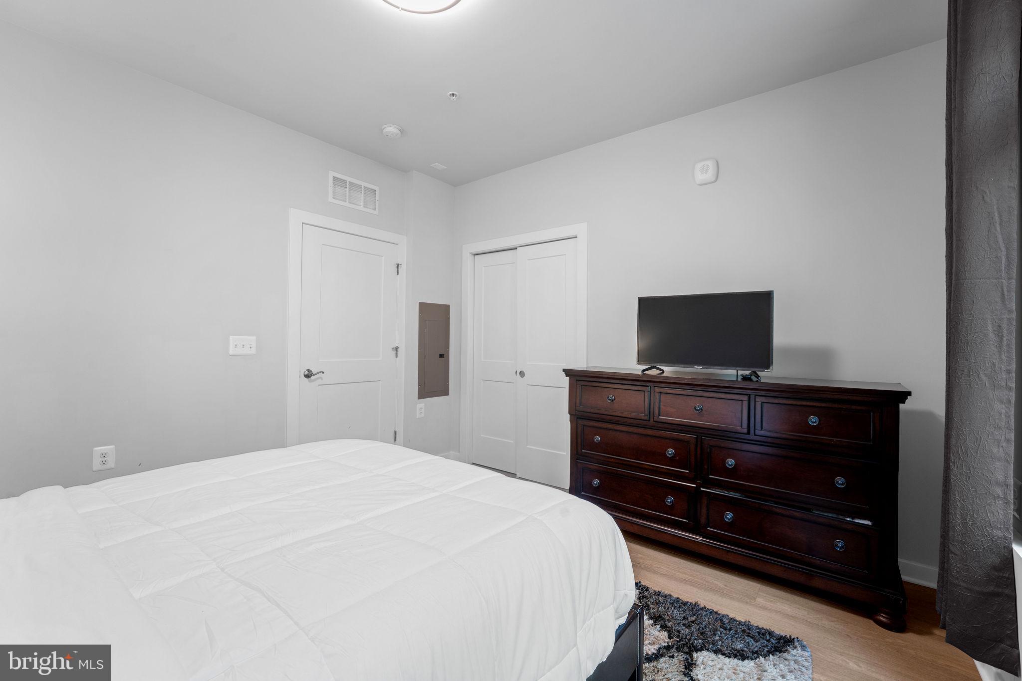1669 Bandit Loop, Unit 101A Reston, VA 20190 - Photo 19 of 35 a bedroom with a bed and a flat screen tv