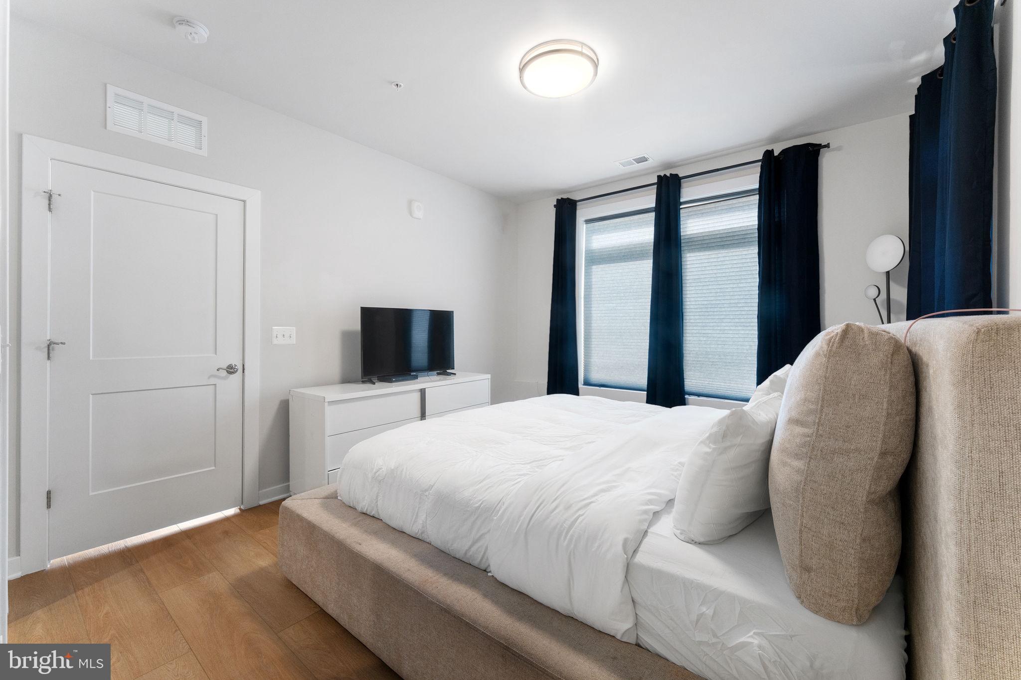 1669 Bandit Loop, Unit 101A Reston, VA 20190 - Photo 25 of 35 a bedroom with a large bed and a tv