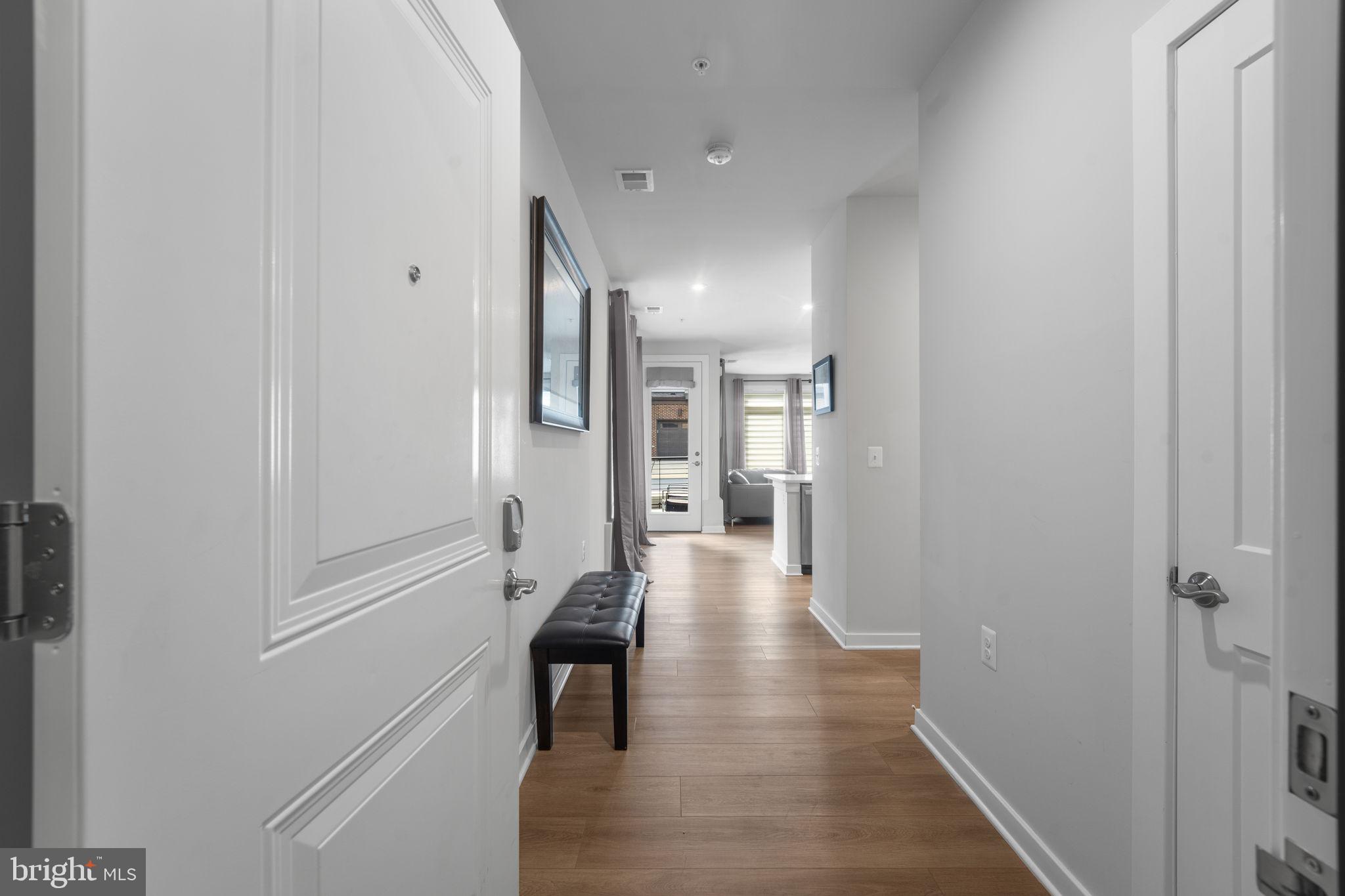 1669 Bandit Loop, Unit 101A Reston, VA 20190 - Photo 5 of 35 a hallway with wooden floor windows and staircase