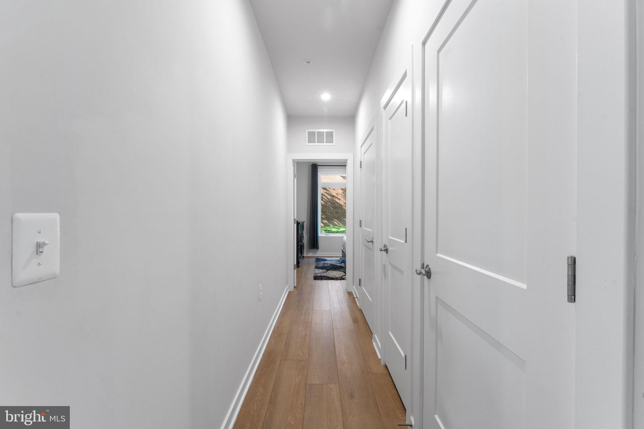 1669 Bandit Loop, Unit 101A Reston, VA 20190 - Photo 7 of 35 a view of a hallway with wooden floor and staircase