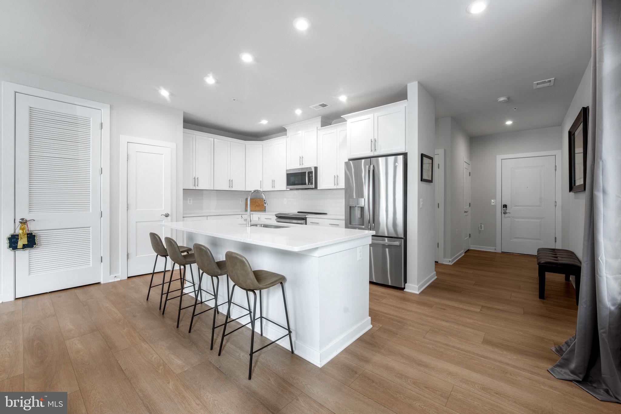 1669 Bandit Loop, Unit 101A Reston, VA 20190 - Photo 9 of 35 a kitchen with stainless steel appliances granite countertop a refrigerator and a stove top oven